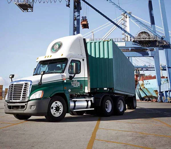 Old Dominion Freight Line truck hauling a green container at a busy shipping port.